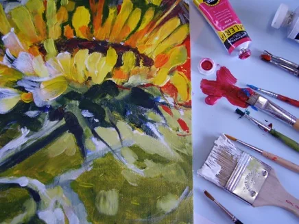 Acrylschilderij van zonnebloemen op een ezel, met verftubes en palet